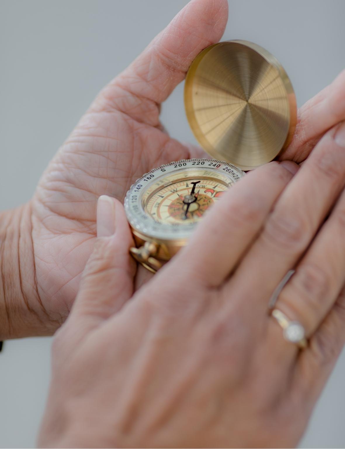 Kompass golden in Händen mit Diamantring